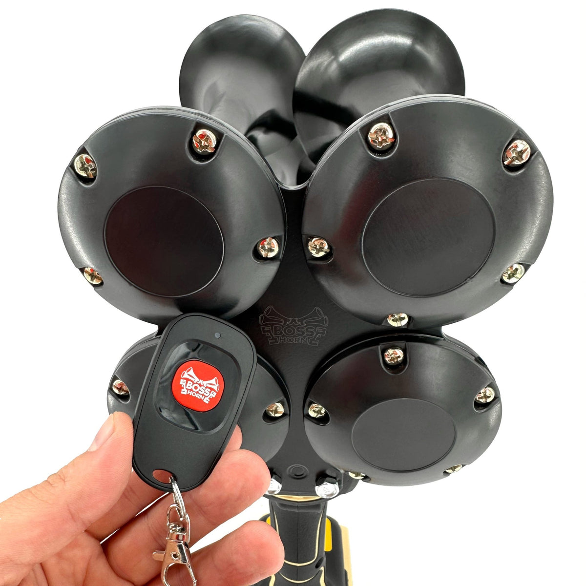 Hand with BossHorn remote control in front of DeWalt Train Horn