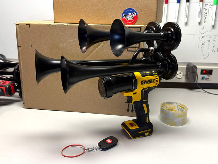 A black quad-trumpet air horn attachment on its battery mount