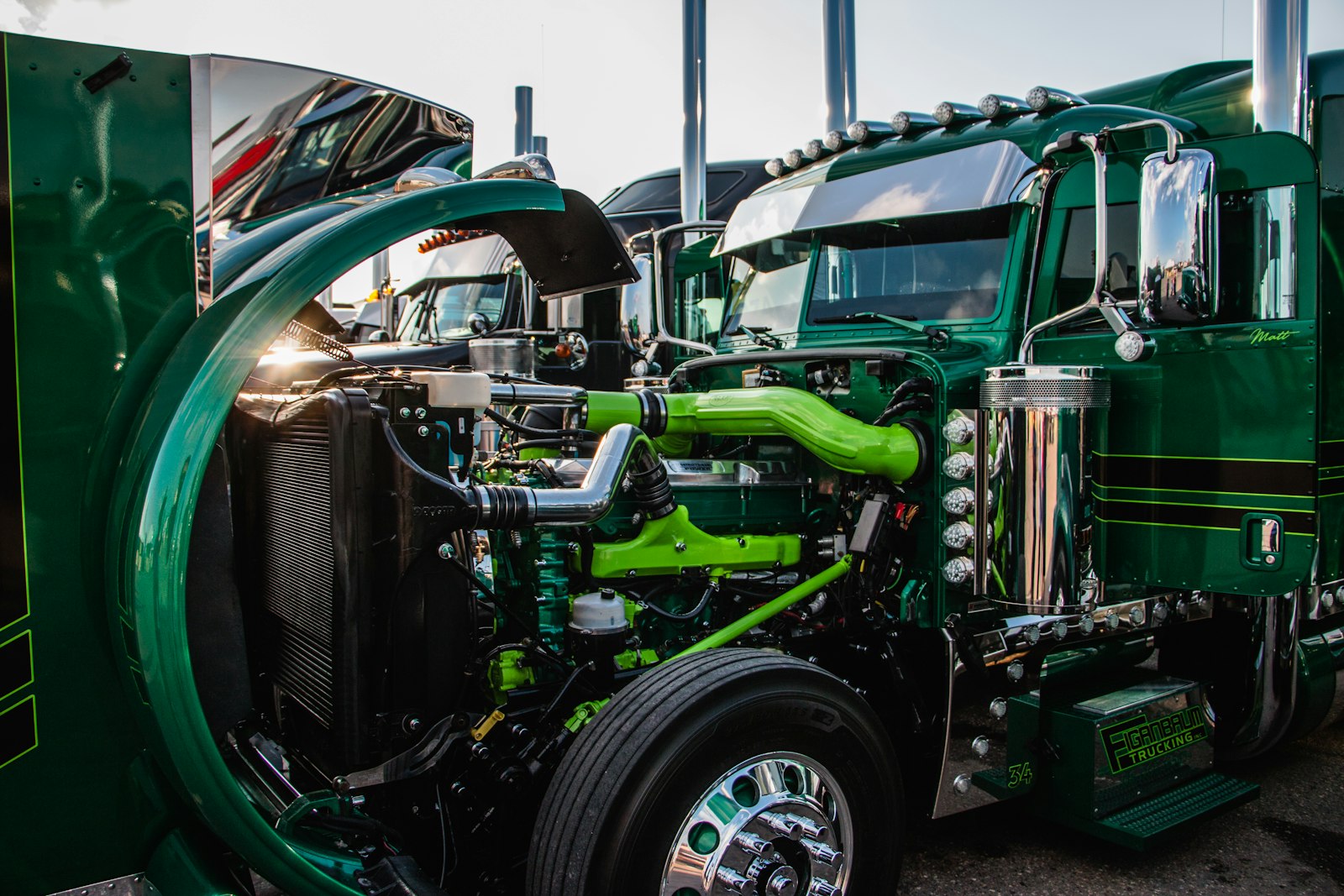 Close-up of the chrome grille and front end of a bright green semi truck, a classic gift idea for truckers and diesel owners
