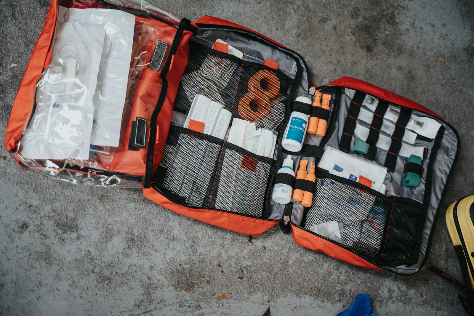 Orange, white and black emergency preparedness go-bag packed with first-aid and safety gear, ready to grab in a crisis