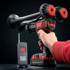 Hand holding a red and black horn with a remote control on a dark background